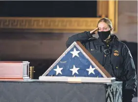  ?? POOL PHOTO BY ANNA MONEYMAKER ?? A Capitol Police officer pays her respects to Sicknick, who was struck in the head with a fire extinguish­er while struggling with the rioters who swarmed through the halls of Congress last month.