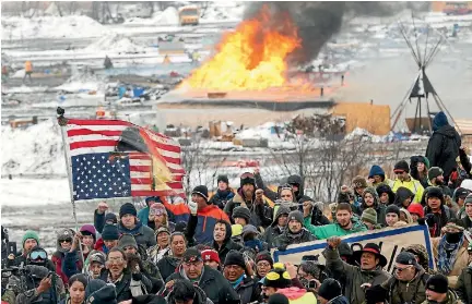  ?? PHOTO: REUTERS ?? Opponents of the Dakota Access oil pipeline march out of their main camp near Cannon Ball, North Dakota, yesterday, an hour before the deadline to leave. A small number of protesters were left behind.
