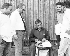  ??  ?? Clients wait as a typist prepares a petition outside a city court in Mumbai.