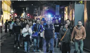  ??  ?? People are led away from the scene of a bloody rampage near London Bridge on Saturday night. Six people are confirmed dead.