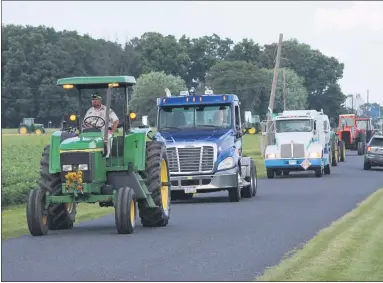  ?? COURTESY OF ANDREW FRANKENFIE­LD ?? David Yoder leads the tractor parade driving Bob’s tractor and coworkers drive his oil trucks.