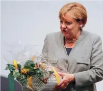  ?? Reuters ?? Angela Merkel carries a present in Dortmund . —