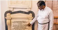  ?? AFP ?? A pastor shows a memorial tablet of Christoper Biden, a potential ancestor of Joe Biden, at St George’s Cathedral in Chennai. —