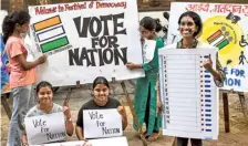  ?? EMMANUAL YOGINI ?? Urgent reminder: Students paint posters in Mumbai on Wednesday urging people to vote.