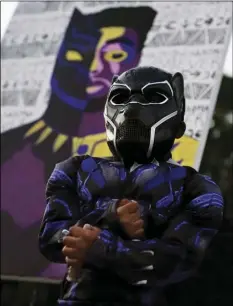  ?? AP PHOTO/BRYNN ANDERSON ?? Mason Wilkes, 4, of South Carolina, poses for his father in a Black Panther costume, in front of a painting during a Chadwick Boseman Tribute on on Thursday in Anderson, S.C.