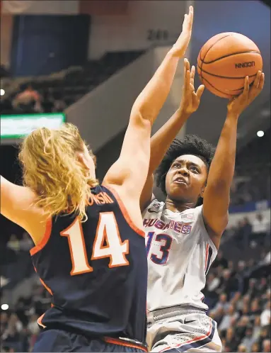  ?? Jessica Hill / Associated Press ?? UConn’s Christyn Williams (13) shoots as Virginia's Lisa Jablonowsk­i defends during the first half of Tuesday night’s game at the XL Center in Hartford.