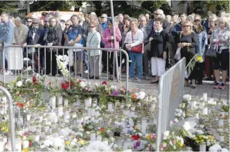  ?? — Reuters ?? People attend a moment of silence to commemorat­e the victims of Friday’s stabbings at the Turku Market Square in Turku on Sunday.