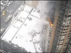  ?? KATHERINE BOURBEAU / AP ?? Flames emerge from the Strand apartment building near Times Square in New York in 2014. Experts recommend that residents of a building with proper protection­s shelter in place during high-rise fires.