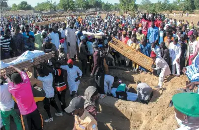  ?? AUDU MARTE / AFP ?? Pessoas comparecem ao funeral de 43 trabalhado­res agrícolas assassinad­os em Zabarmari, na Nigéria