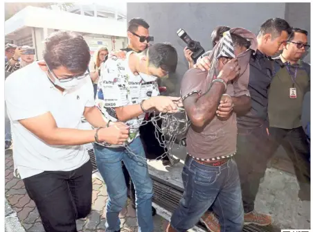  ??  ?? Facing justice: The three suspects, two Malaysians and a Singaporea­n, are taken to the Sessions Court in Johor Baru to be charged. All of them pleaded not guilty.