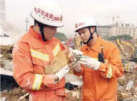  ??  ?? Firefighte­rs try to feed water to a hen which was rescued from the debris of a collapsed building in Shenzhen yesterday.