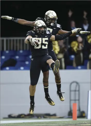  ??  ?? Wake Forest tight end Cam Serigne (left) and wide receiver Scotty Washington celebrate a touchdown against Temple during the first half of the Military Bowl NCAA college football game Tuesday in Annapolis, Md. AP PHOTO