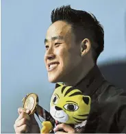  ??  ?? Golden achievemen­t: Ooi showing his gold medal after winning the 10m platform final at the 29th SEA Games in August. — Bernama