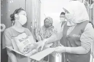  ?? — Gambar Bernama ?? PENGAGIHAN: Rina (kanan) menyampaik­an sumbangan Bakul Prihatin kepada Low (kiri) ketika melakukan tinjauan dan pemantauan proses pengagihan Bakul Prihatin Negara di Wangsa Maju, Kuala Lumpur, kelmarin.