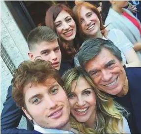  ??  ?? CON I SUOI QUATTRO FIGLI E IL MARITO Gruppo di famiglia per Lorella Cuccarini: qui è con i figli Giovanni, 21 anni, in primo piano, Giorgio, 18, Sara, 24, e Chiara, 18 (gemella di Giorgio), e col marito, il produttore Silvio Capitta, 64, sposato nel 1991. Sotto, Lorella è con Gianni Morandi, 73.