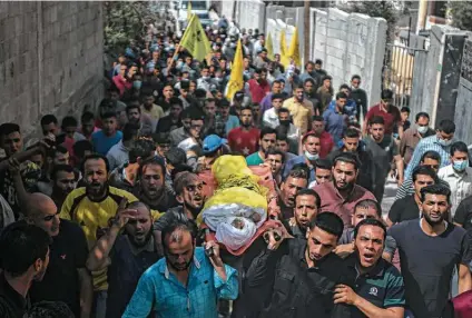  ?? Khalil Hamra / Associated Press ?? Palestinia­n mourners carry the body of 11-year-old Hussain Hamad, who was killed by an explosion in the ongoing conflict between Israel and Hamas, during his funeral Tuesday in Beit Hanoun, northern Gaza Strip.