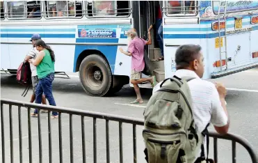  ??  ?? A passenger gets off on the middle of the road. Pix by Anuradha Bandara