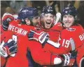  ?? ALEX BRANDON/ASSOCIATED PRESS ?? Capitals defenseman John Carlson, center, celebrates his goal against the Knights with Alex Ovechkin, left, and Nicklas Backstrom during Game 4 of the Stanley Cup Final on Monday.