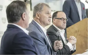  ?? DARREN CALABRESE/ THE CANADIAN PRESS ?? CFL commission­er Randy Ambrosie, centre, with Maritime Football Limited Partnershi­p founding partners Bruce Bowser, left, and Anthony LeBlanc, discusses a franchise in Halifax. Ambrosie also answered questions from fans.