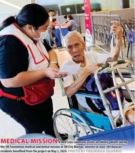  ?? PHOTO BY FREDERICK SILVERIO ?? MEDICAL MISSION
A Red Cross volunteer assists an elderly patient during the SM Foundation medical and dental mission at SM City Marilao, wherein at least 584 Bulacan residents benefited from the project on May 2, 2024.