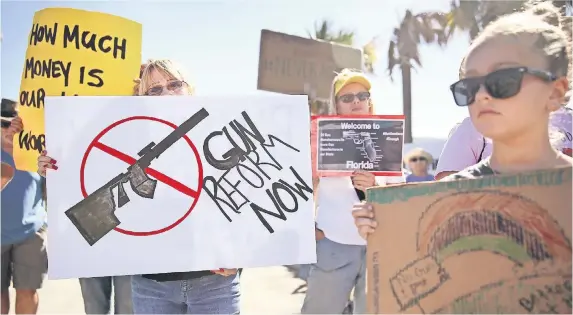  ??  ?? Activistas protestaro­n ayer afuera de la empresa Kalashniko­v USA, fabricante de armas como el rifle AK-47, en Pompano Beach, Florida.