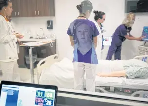  ??  ?? Nancy Allen, an instructor, controls a simulation for students of the Clemson University School of Nursing, at the Greenville Memorial Medical Campus in South Carolina, on Oct 1.