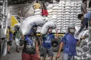  ?? VEEJAY VILLAFRANC­A / BLOOMBERG ?? Workers carry sacks of rice inside a National Food Authority warehouse in Valenzuela, Philippine­s. The global staple food has posted increases in price for three straight months.