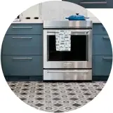  ??  ?? While the tile floor and custom cabinetry have a traditiona­l feel to them in keeping with the age of the house, the stove is resolutely modern