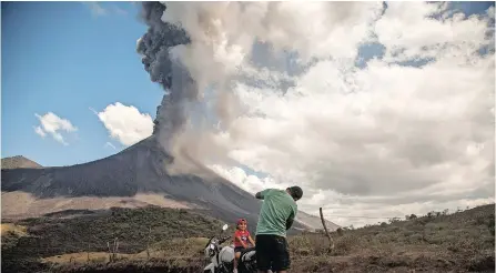  ??  ?? A FATHER takes a picture of his son with an eruption of the Pacaya volcano in the background, in San Vicente Pacaya, Guatemala. The Pacaya volcano, one of the most active volcanos of the 32 in Guatemala, increased its activity with the launch of volcanic material at high altitude and ash that was dispersed up to 25 kilometers away from its crater, from which three lava flows have already formed. | EPA