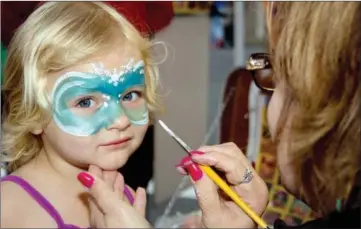  ?? RVER VALLEY & OZARK FILE PHOTOS ?? Audrey Magie has her face painted in a Frozen theme by Johnnie Terry at the 2016 Toad Suck Daze festival in Conway.