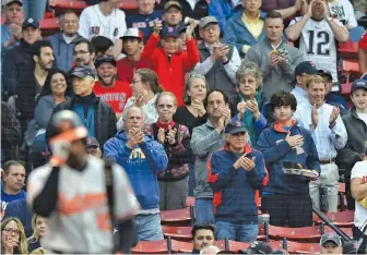  ?? STAFF PHOTO BY CHRISTOPHE­R EVANS ?? SUPPORT SYSTEM: Adam Jones tips his helmet as fans cheer him in his first at-bat last night at Fenway.