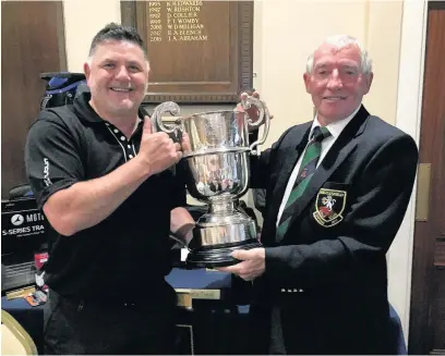  ??  ?? Paul Tomlinson receives the President’s Cup from Macclesfie­ld President Dave Brereton