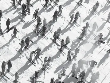  ?? CAYCE CLIFFORD/THE NEW YORK TIMES ?? Socially distanced skiers and snowboarde­rs wait to board the Squaw One Express lift in December at Squaw Valley Ski Resort in Olympic Valley, California.