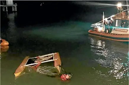  ??  ?? Police and the Coastguard rescue a man whose catamaran repeatedly capsized in Tasman Bay last Wednesday.