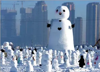  ?? XINHUA/WANG KAI ?? People watch snowman sculptures at an ice and snow park in Harbin, the capital of northeast China’s Heilongjia­ng province. Altogether, 2,018 cute snowmen were displayed to greet the year 2018.