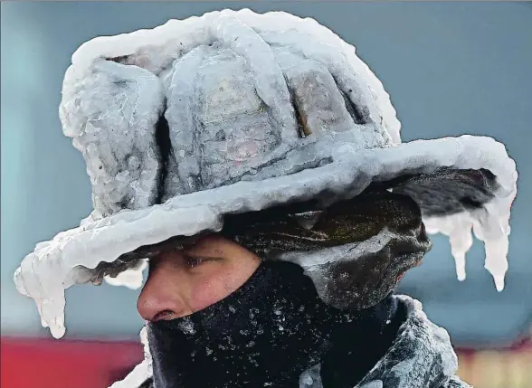  ?? C. EVANS / POLARIS / CONTACTO ?? El bombero Bobby Lehman tiene el casco congelado después de participar en la extinción de un fuego salvaje en Nahant (Massachuse­tts)