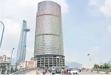  ?? ?? Traffic in front of a building under constructi­on and owned by Van Thinh Phat group in Ho Chi Minh City.