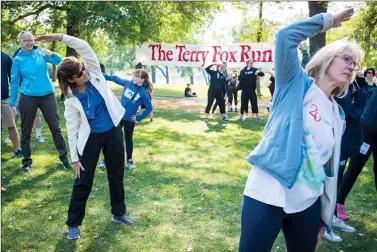  ?? Herald photo by Tijana Martin ?? Residents stretch before participat­ing in the annual Terry Fox Run around Henderson Lake on Sunday. @TMartinHer­ald