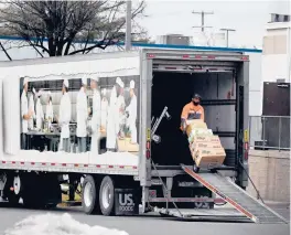  ?? OLIVIER DOULIERY/GETTY-AFP ?? A worker delivers goods at a grocery store in Fairfax, Va. The economy, squeezed by inflation and still gripped by virus cases, is expected to slow this year.