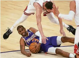  ?? ROSS D. FRANKLIN/AP ?? Suns guard Chris Paul (3) slides along the floor while Bulls guard Tomas Satoransky defends during the first half Wednesday.