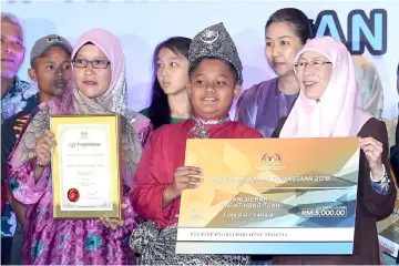  ?? — Bernama photo ?? Wan Azizah (right) presents Hang Tuah award to Muhammad Darwisy Abdullah at the closing ceremony of the Conference on Sustanable Wellbeing of Children, Persons with Disabiliti­es and Senior Citizens at Putrajaya.