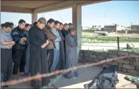 ?? FELIPE DANA / ASSOCIATED PRESS ?? Relatives and friends pray next to the body of a man who was killed during fighting between Iraqi security forces and IS militants on the western side of Mosul, Iraq.