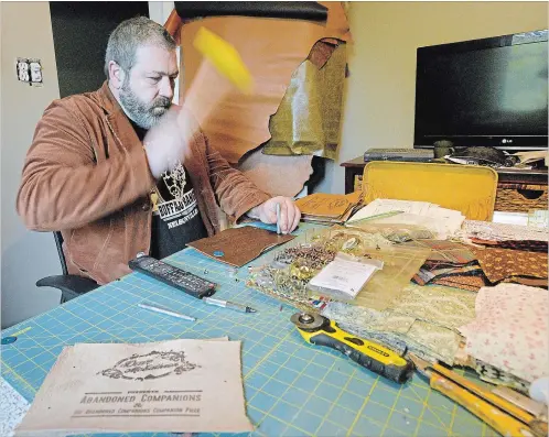  ?? PHOTOS BY CATHIE COWARD THE HAMILTON SPECTATOR ?? Dave McEathron has returned to writing songs and he's now releasing his first solo album "Abandoned Companions." McEathron also hand-made the leather covers of each CD. He is seen here putting the finishing touches on one of the leather CD cases.