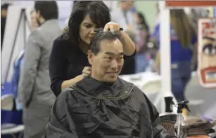  ??  ?? City Attorney for the city of Imperial Dennis Morita gets a haircut from Smiles and Styles Beauty Salon at the 20th annual Joint Chambers of Commerce Business Showcase. EDWIN DELGADO PHOTO