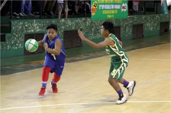  ??  ?? ONE ON ONE. An SLU-LES dribbler moves past a UC defender during the eliminatio­ns round of the Milo BEST Center Twin Tournament at the Easter College Gym. Photo by Roderick Osis