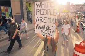  ?? ANTHONY SOUFFLE/STAR TRIBUNE ?? Protesters carry signs as they march against police violence from Loring Park to City Hall Friday in Minneapoli­s, Minn.