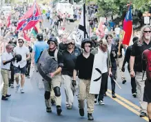  ??  ?? Demonstrat­ors march in a white nationalis­t rally that turned deadly in Charlottes­ville, Virginia, on Saturday. Is there a message in the suburban-dad khakis/golf shirt look they chose, Jack Knox wonders.