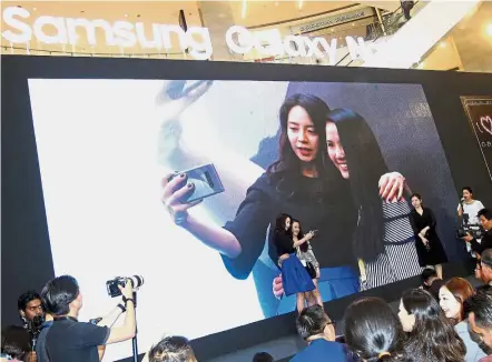  ??  ?? Shooting star: Song taking a selfie with a fan during the launch event at Pavilion KL.