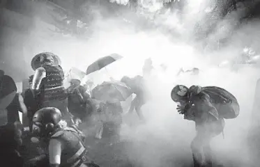  ?? MARCIO JOSE SANCHEZ/AP ?? Federal officers launch tear gas at demonstrat­ors during a Black Lives Matter protest July 26 in Portland, Oregon.