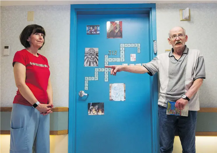  ?? GERRY KAHRMANN/PNG ?? Evelyn Sanduleak, left, and Dennise Keefe pose outside Keefe’s personaliz­ed painted door to his room at the Youville Residence.